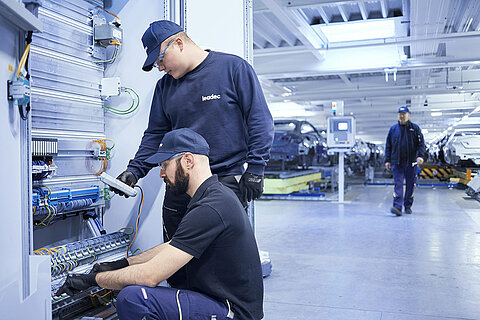 Two Leadec employees analyzing faults and repairing installed electronics.