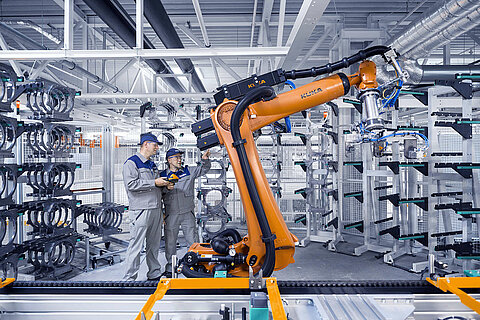 Two Leadec employees maintaining a robot in a production.
